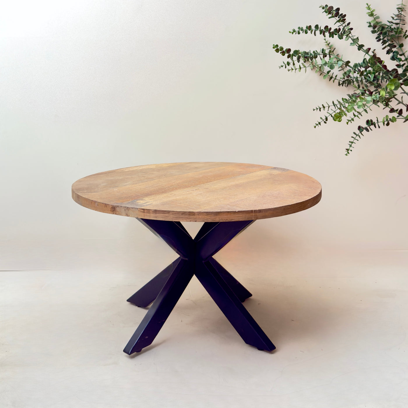 Round wooden table with a purple metal base on a white background