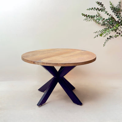 Round wooden table with a purple metal base on a white background