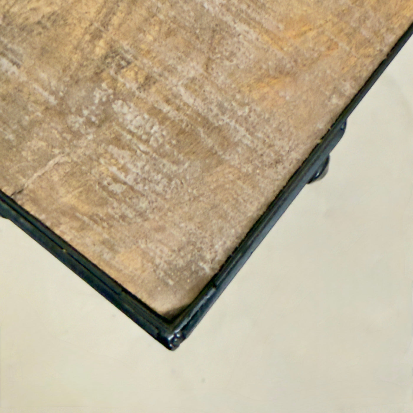 Close-up of a ceramic tile with a beige and brown pattern on a light gray background