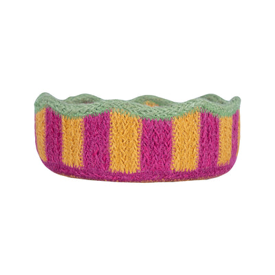 Knitted headband with green, pink, and yellow stripes on a white background