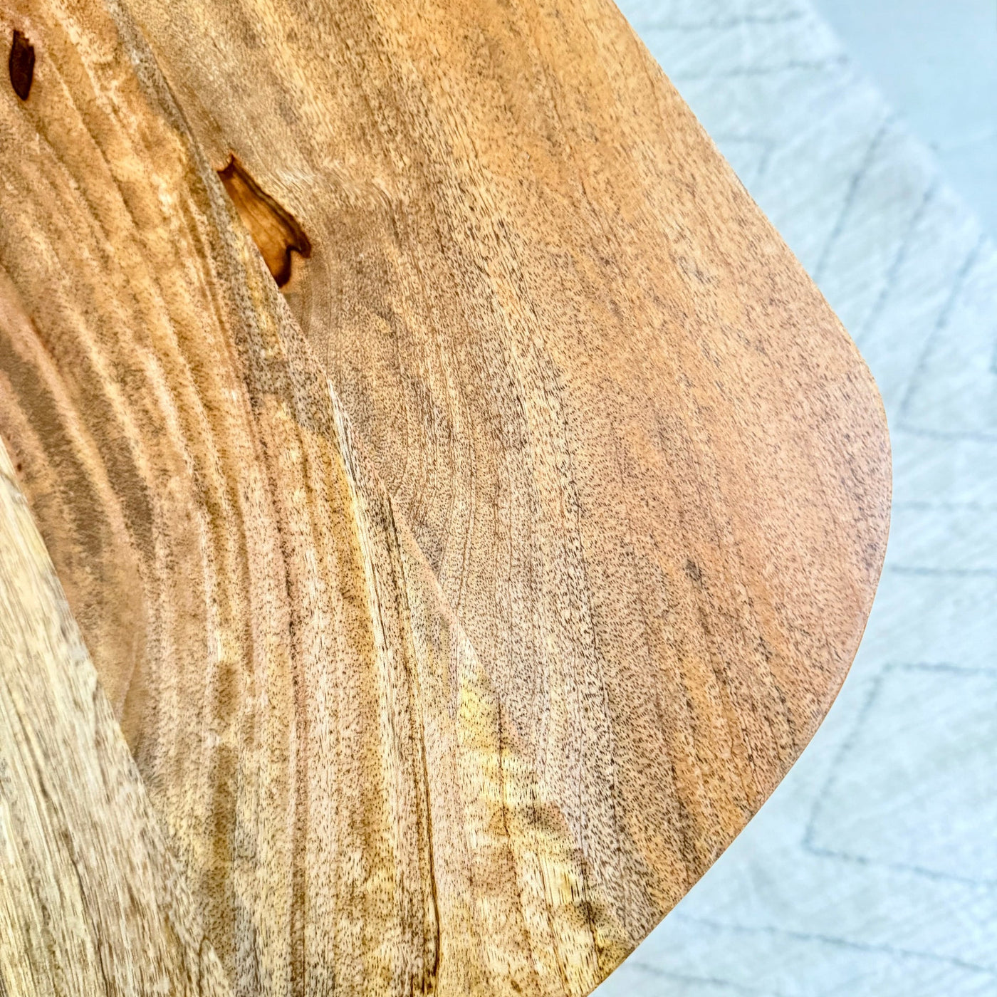 Close-up of a wooden surface with a small insect on a light blue textured background