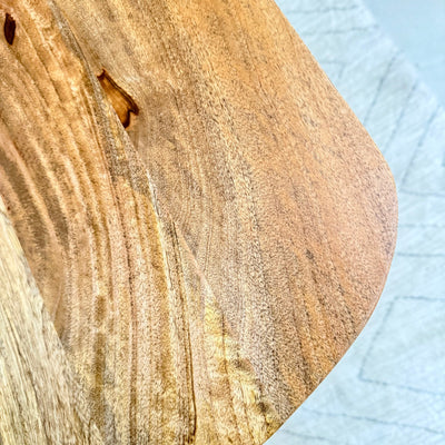 Close-up of a wooden surface with a small insect on a light blue textured background