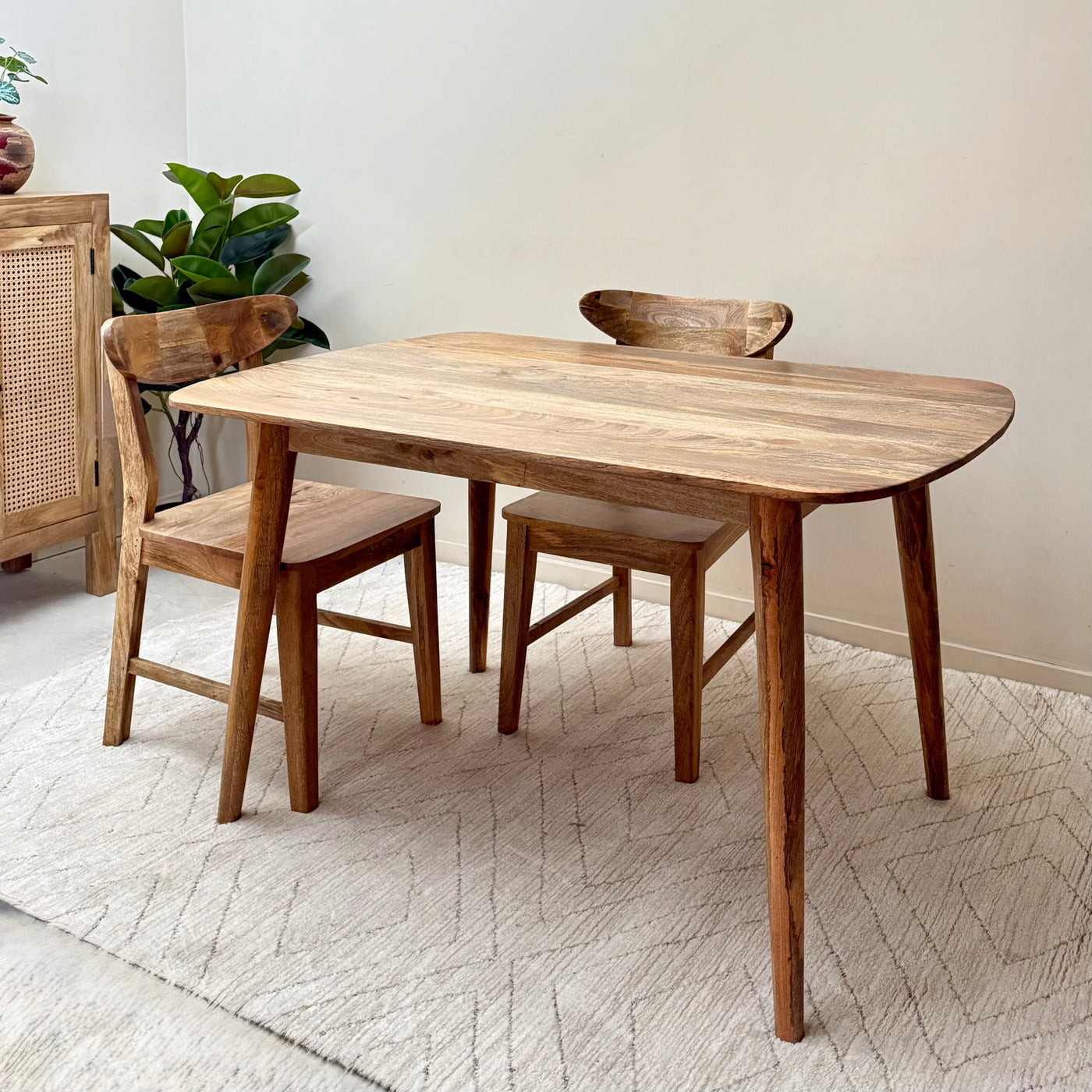 Wooden dining table with chairs on a light-colored floor.-Mrs Robinson