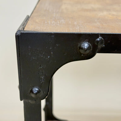 Close-up of a metal bracket on a wooden surface with a blurred background