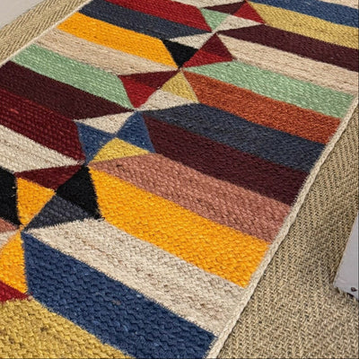 Colorful geometric-patterned rug on a carpeted floor with a neutral wall background