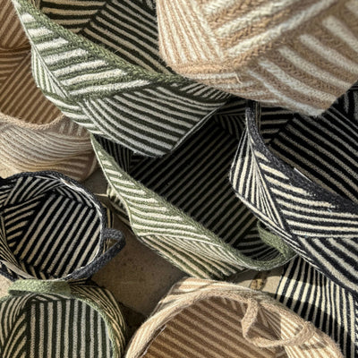 Collection of woven baskets with striped patterns in various colors.
