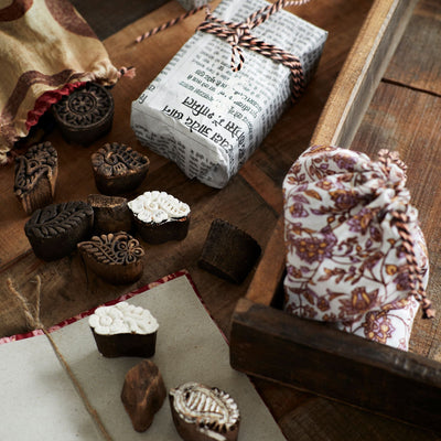 Decorative items including a box, bags, and small containers on a wooden surface.