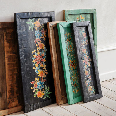 Decorative wooden trays with floral patterns on a light wooden floor.