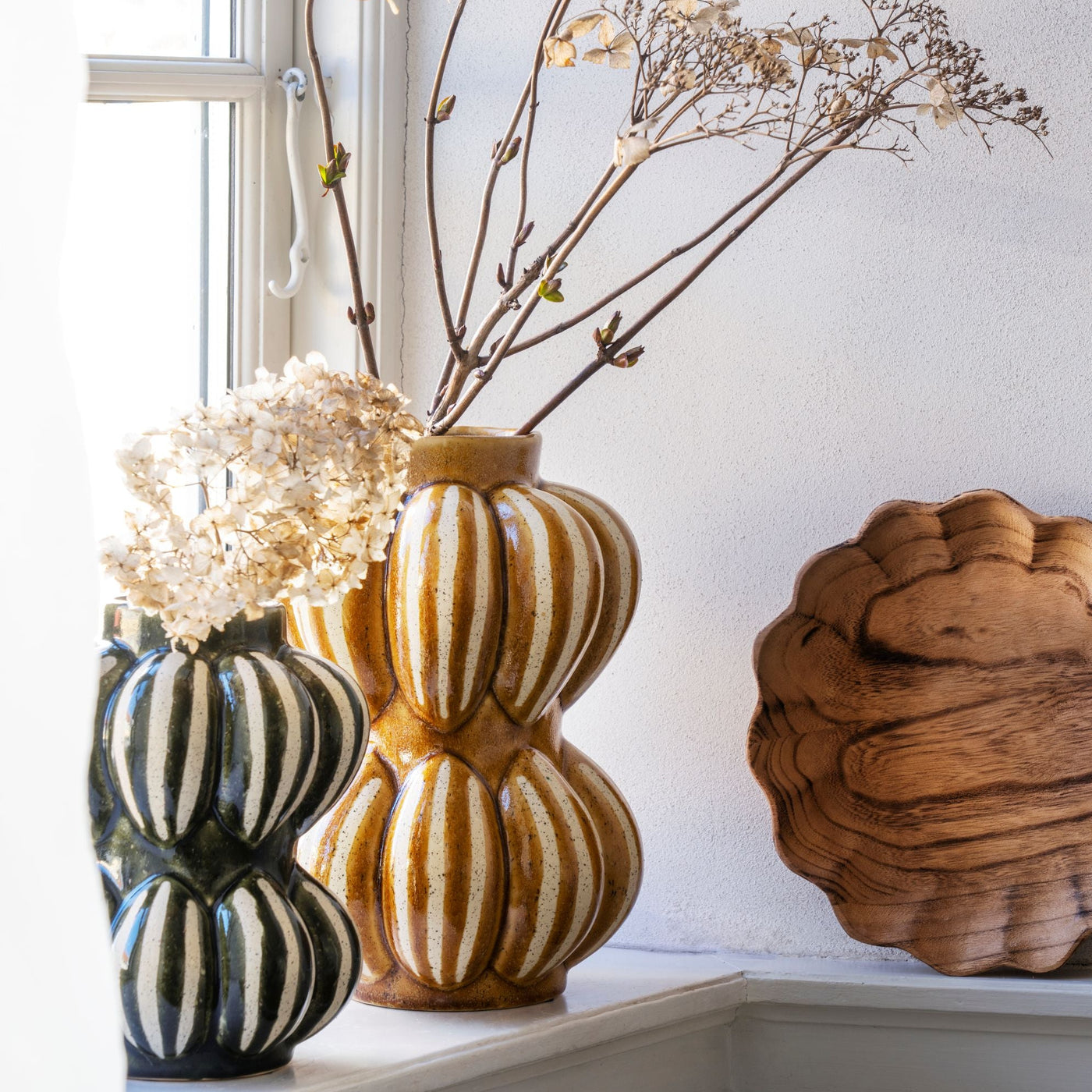 Decorative tray with floral arrangements on a windowsill
