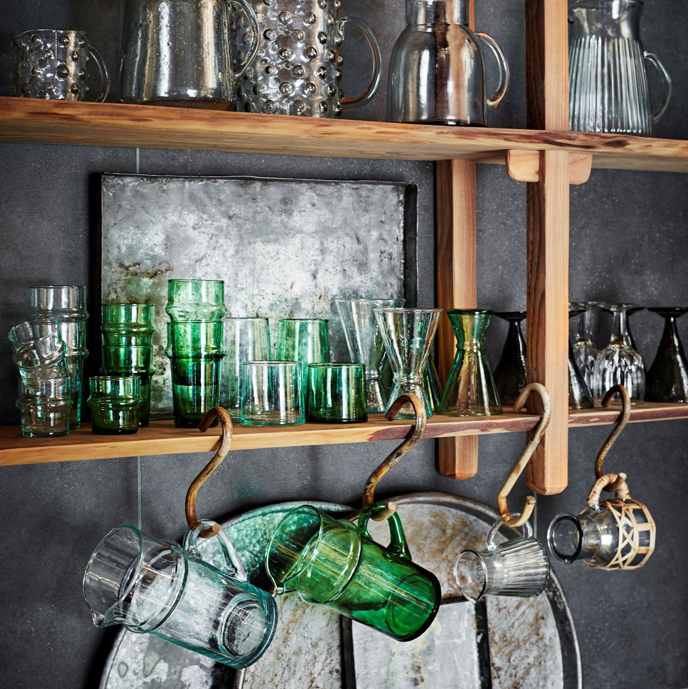 Wooden shelves with various glassware against a dark wall